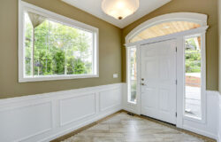 A Entrance Hallway With a Large Window With Trim & Wainscoting Under It Types of Interior House Trim