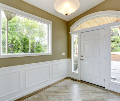 A Entrance Hallway With a Large Window With Trim & Wainscoting Under It Types of Interior House Trim