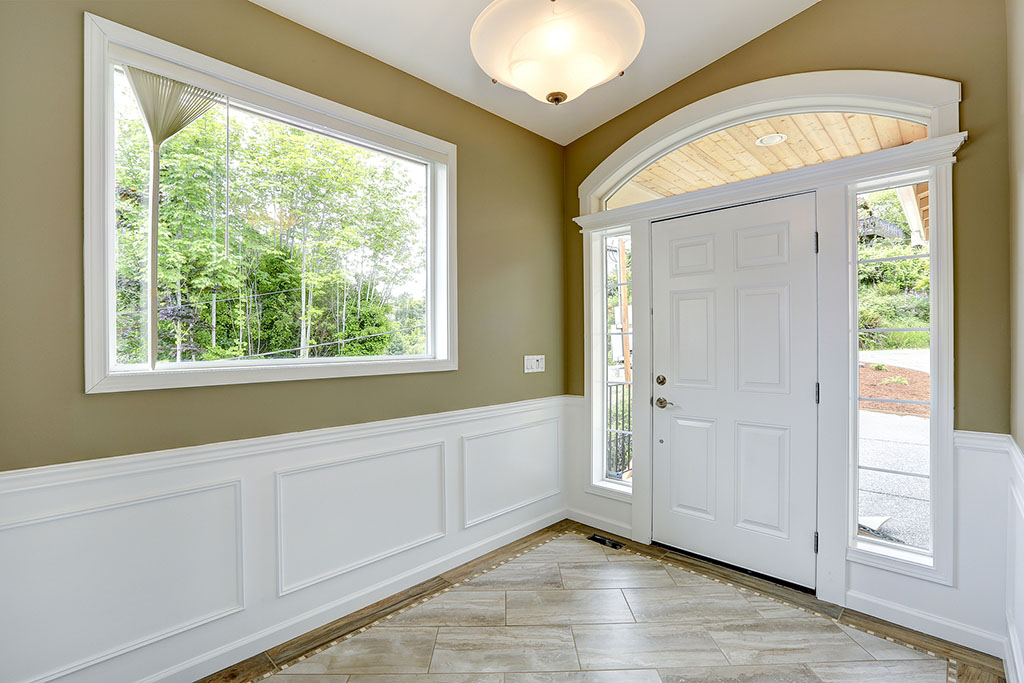 A Entrance Hallway With a Large Window With Trim & Wainscoting Under It Types of Interior House Trim