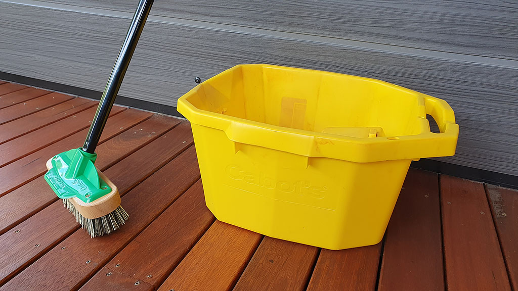 Closeup Of A Broom And A Yellow Bucket Sitting On A Wooden Deck Maintenance