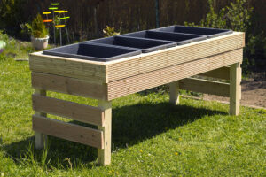 A Diy Raised Planter Box Sitting In A Yard With Plastic Bins Inside Of It